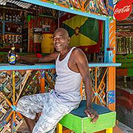 Lokale man drinkt Carib bier in Charlie's Bar, Happy Hill, Saint George op het Carribische eilandGrenada